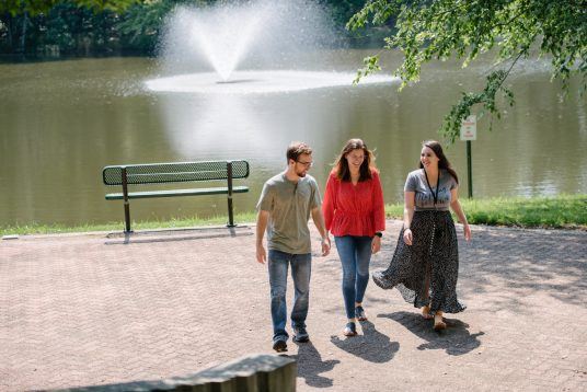 team members walking around outside by lake