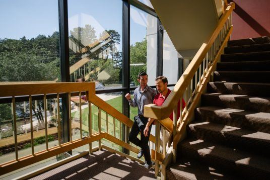 Client Services team members walking up stairs in hallway