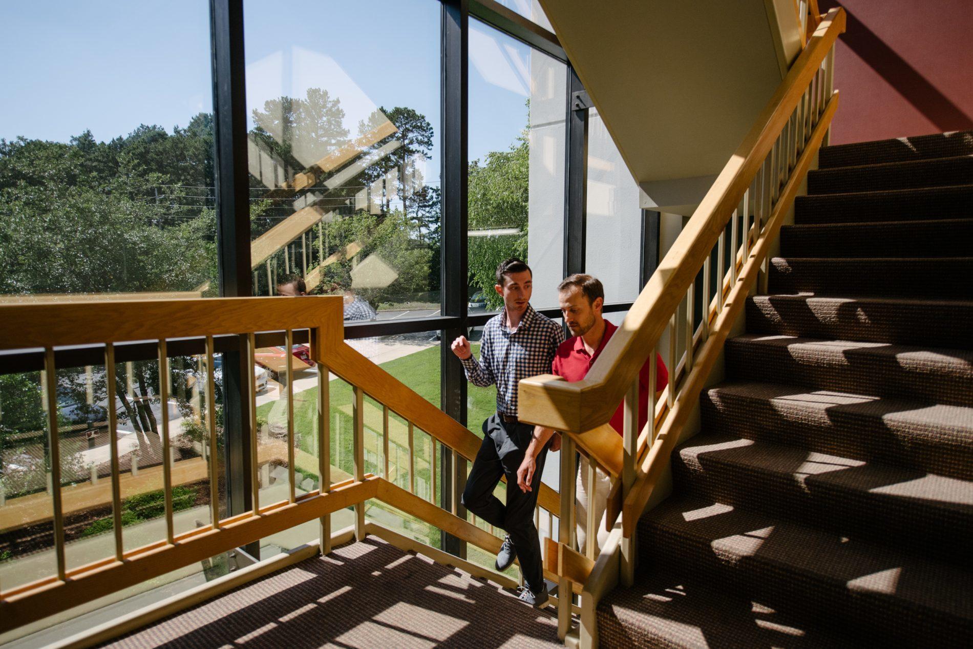 Client Services team members walking up stairs in hallway