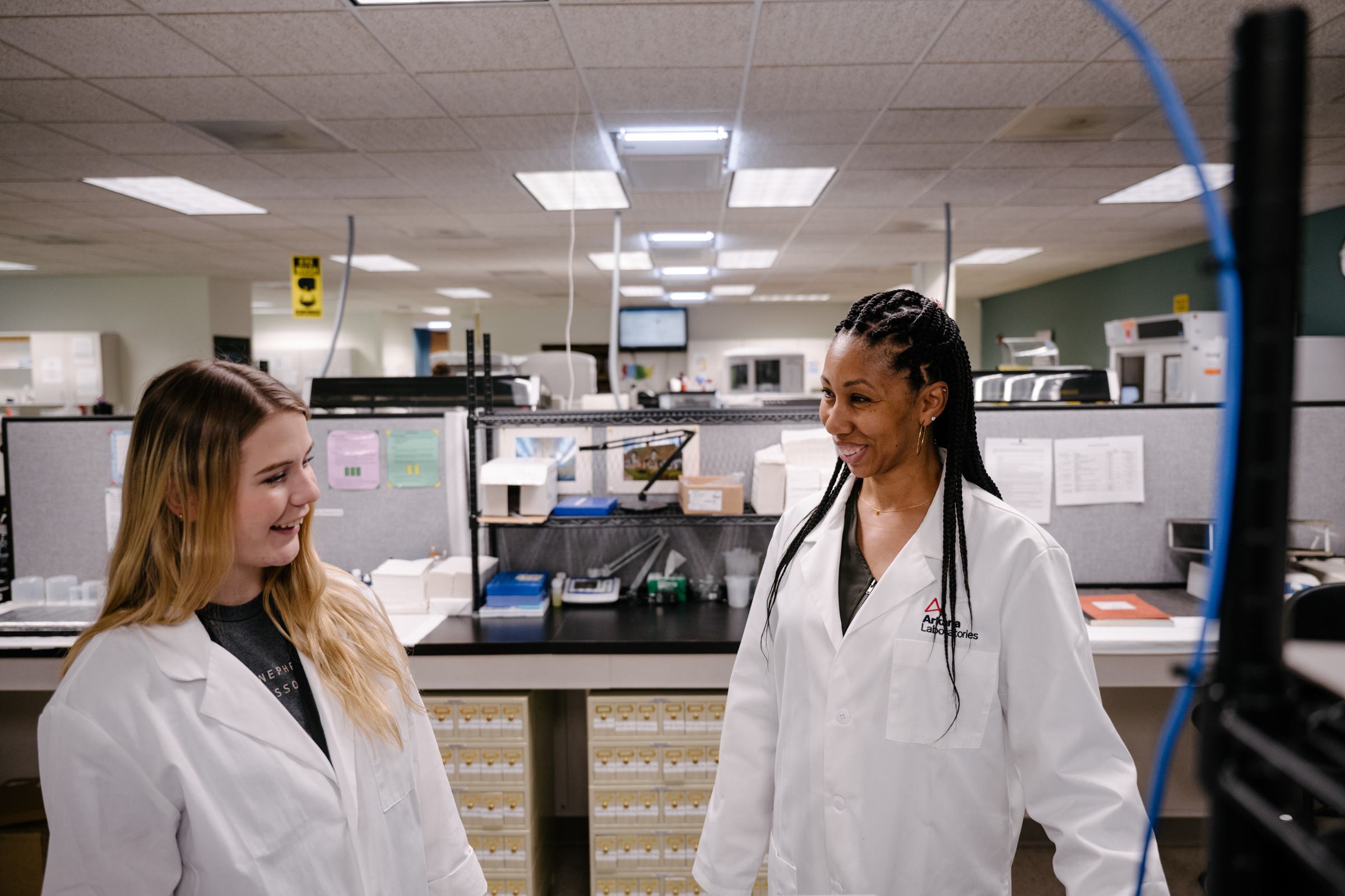 two lab technicians standing and talking in laboratory