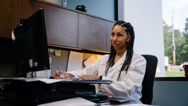 person at desk smiling at computer