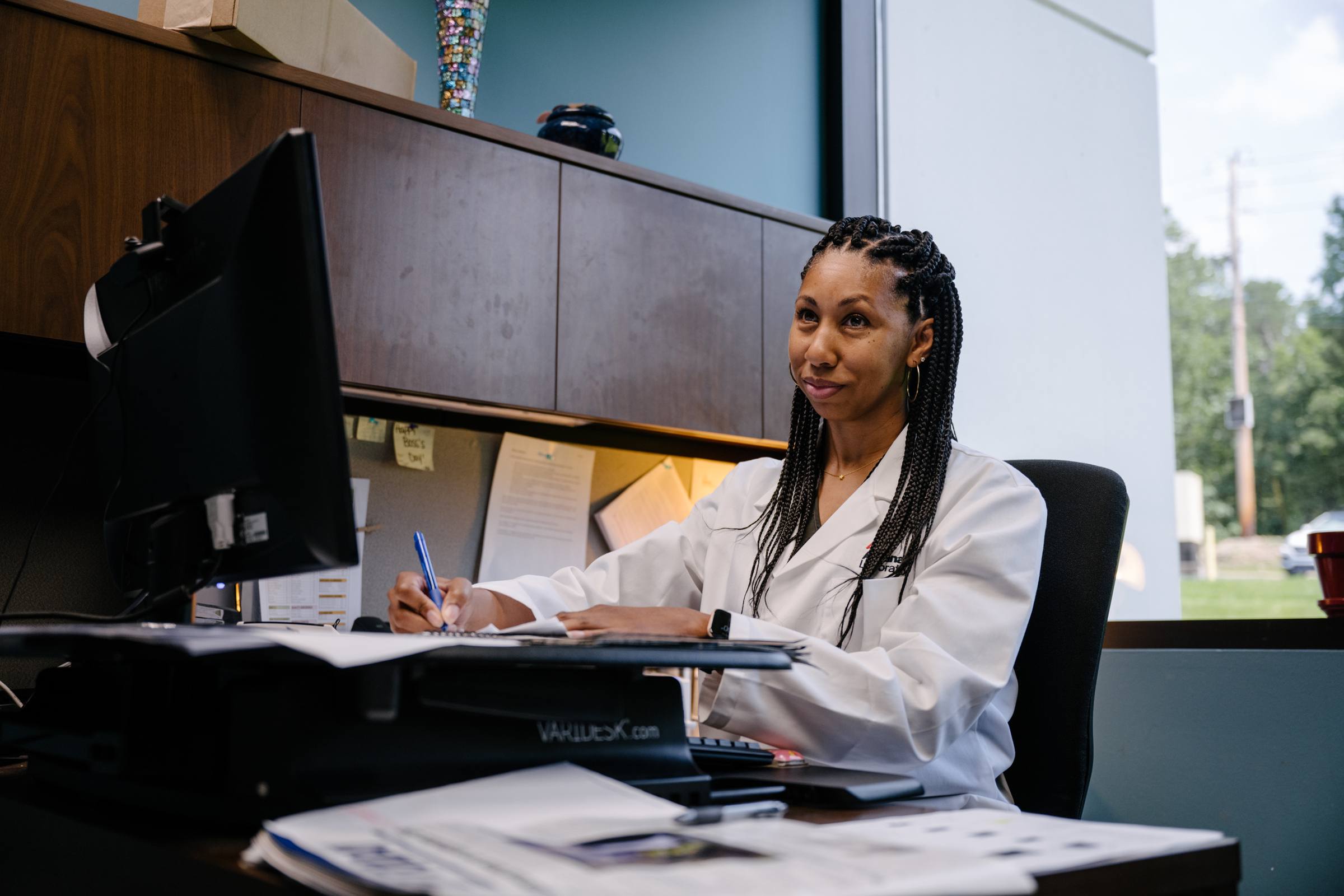 lab team member looking at papers while sitting at desk