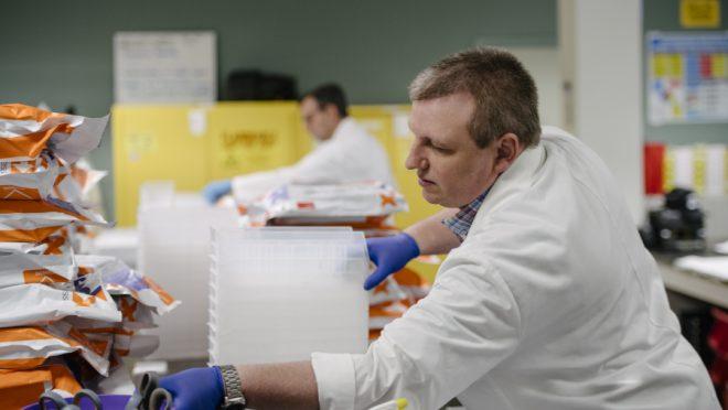 lab team member organizing renal kits as they are delivered by fedex