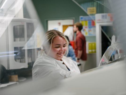 lab team member processing slides and placing slides in stainers - Contact Arkana Labs