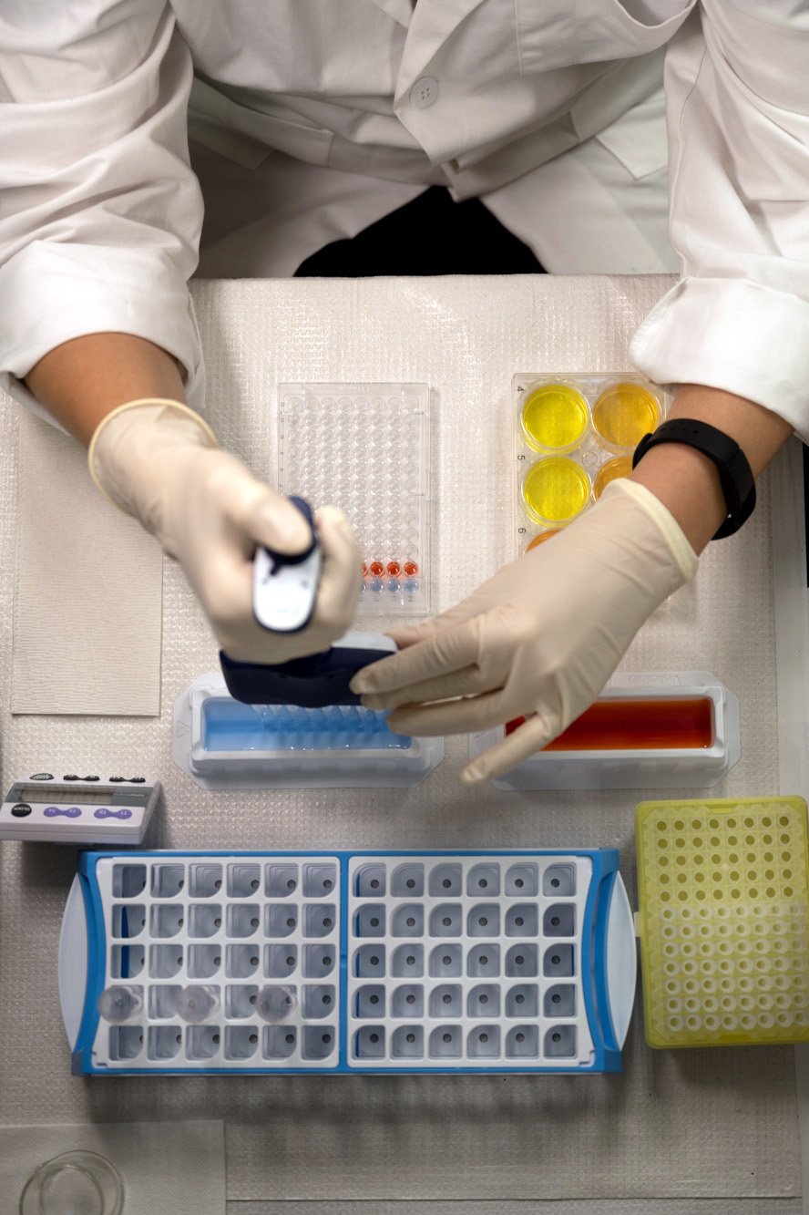 lab technician using pipette to place stain into individual cassette