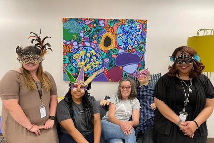 transcription team wearing masquerade masks