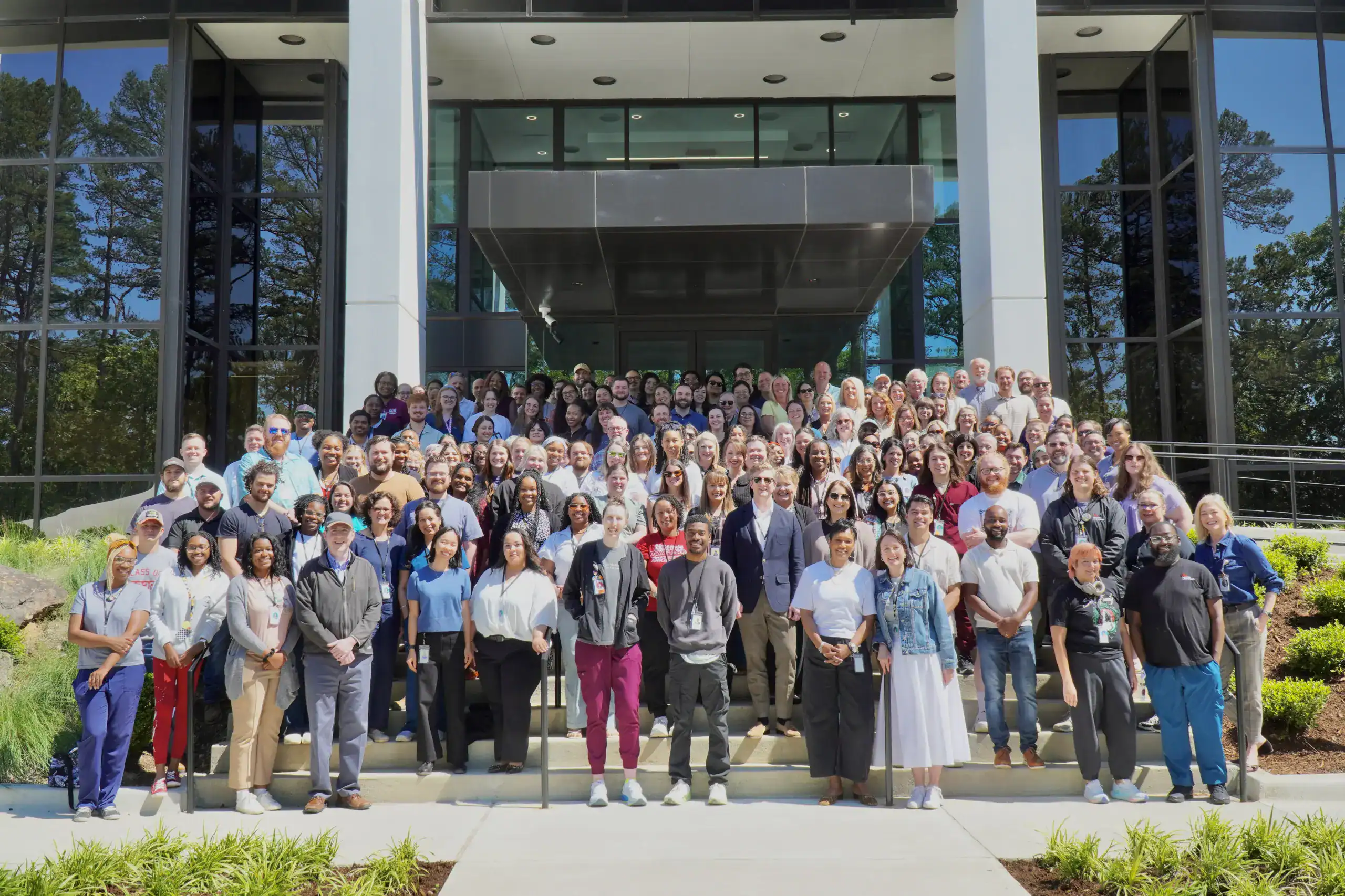 All Arkana employees posing for a photo on the steps in front of the building